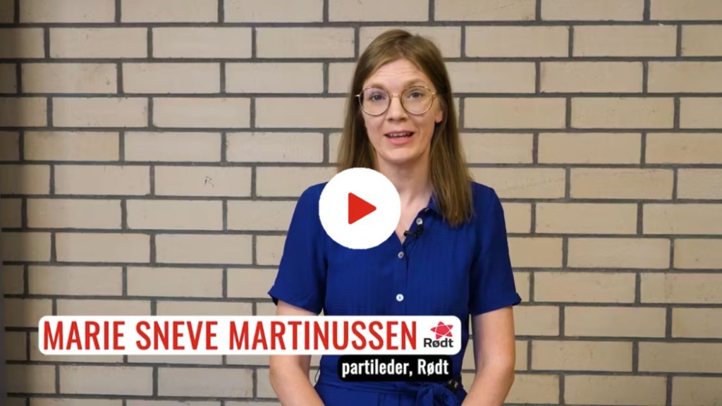 Partilederen i partiet Rødt navnet i røde bokstaver "Marie Sneve Martinussen". Hun står foran en murvegg.